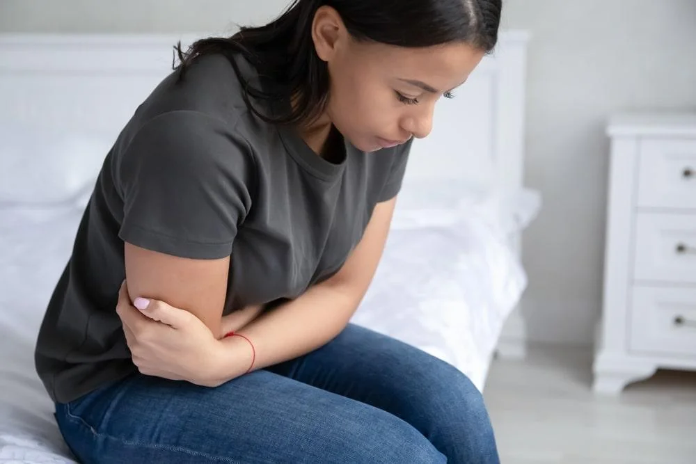 Woman holding her belly experiencing pain