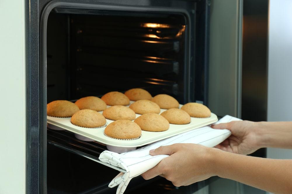A person putting biscuits to the oven