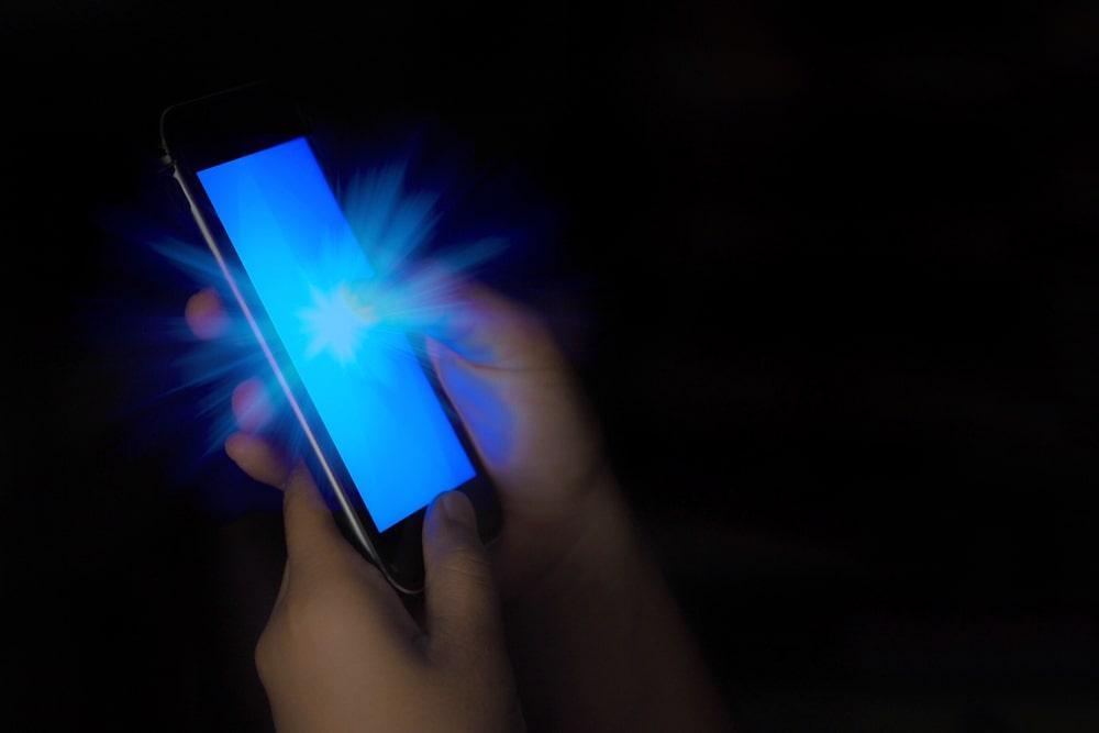 A Person Holding a Bright Cell Phone in the Dark