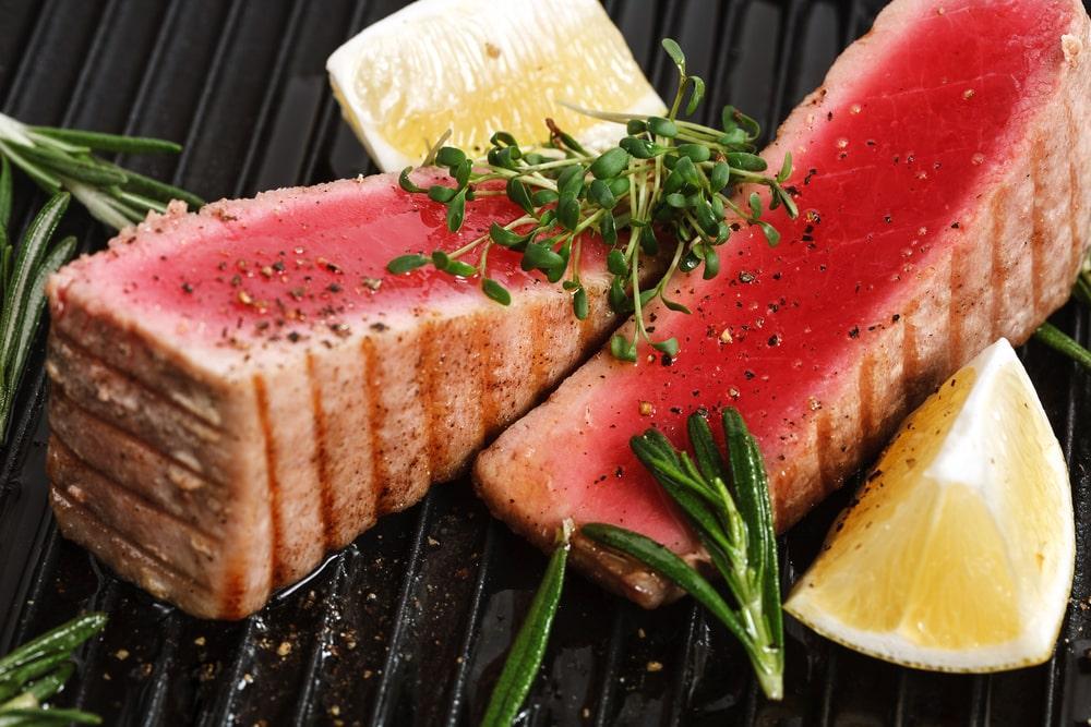 Two Pieces of Tuna With Lemon and Rosemary on a Grill