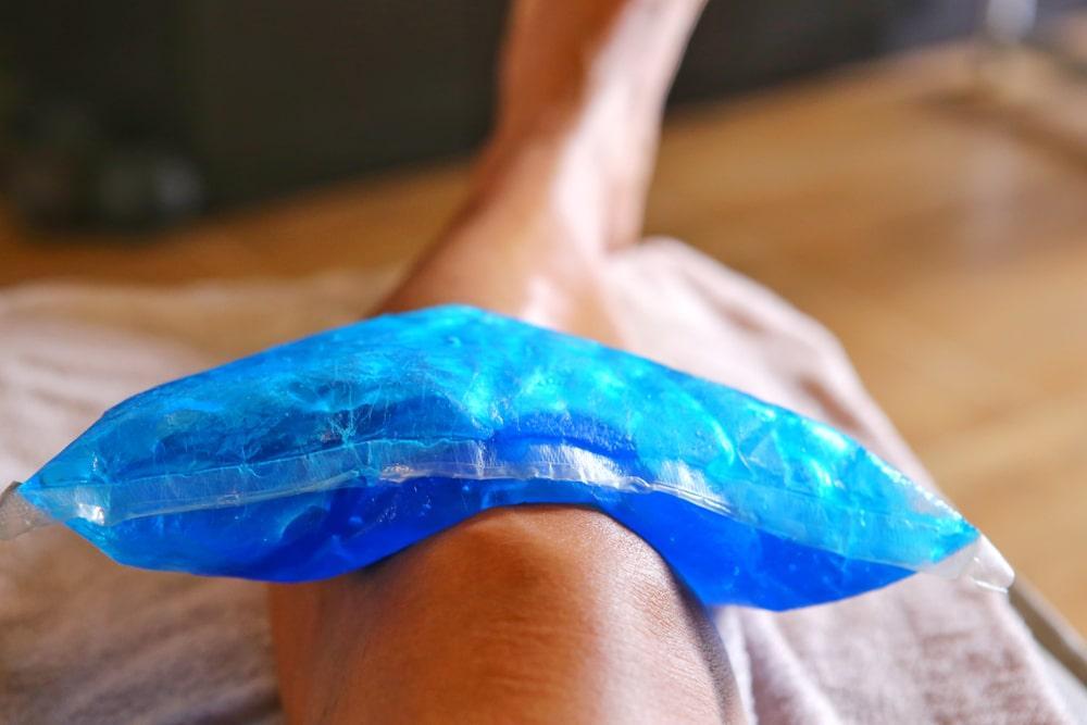 a person lying on the bed with ice on the knee