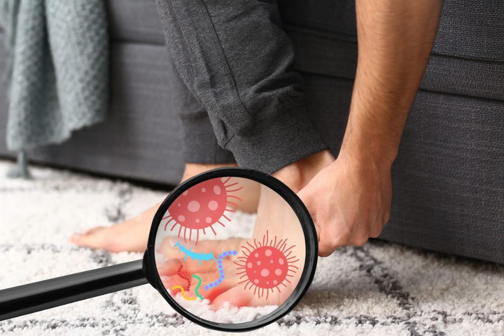 A Magnifying Glass on a Person’s Feet Showing What Causes Toenail Fungus