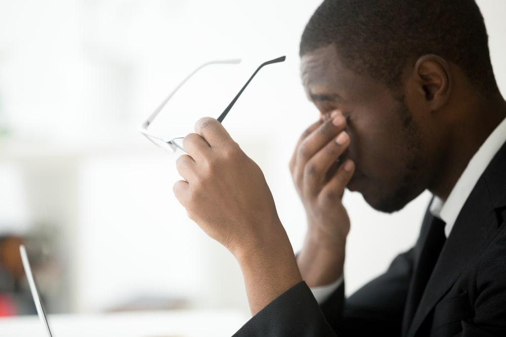 A Stressed Businessman Rubbing His Eyes