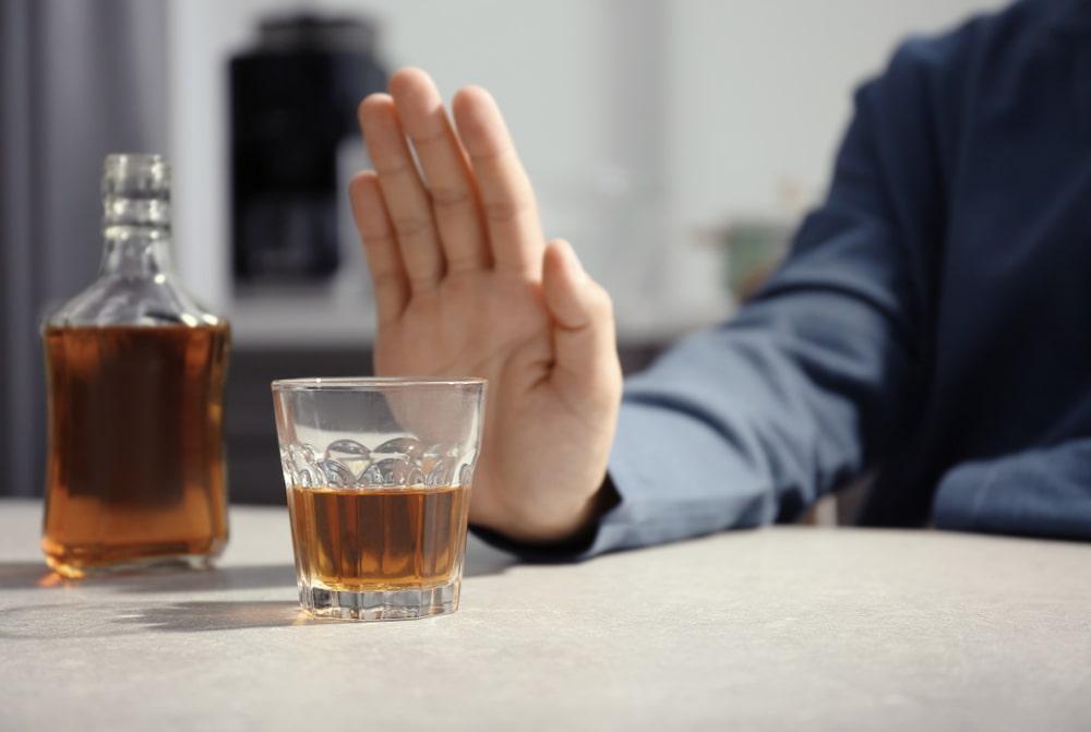 A Person Refusing to Drink Alcohol by Pushing the Glass With a Hand