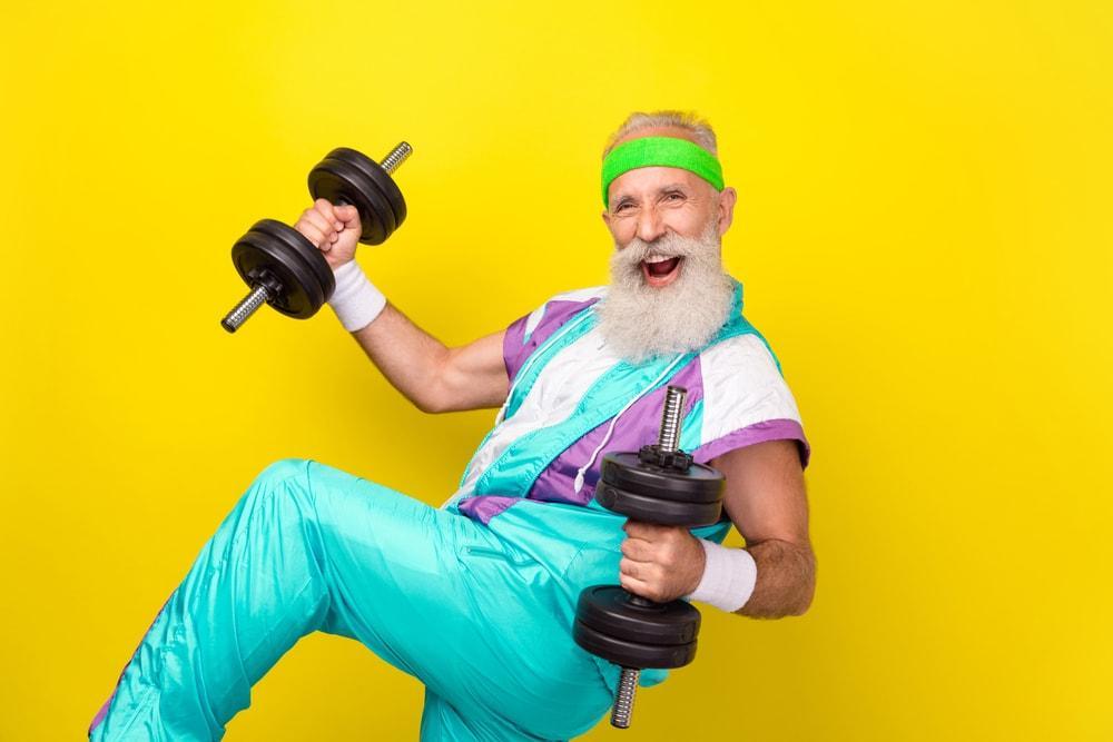 A Senior in a Colorful Outfit Holding Weights After Learning About 10 Best Supplements for Men Over 40