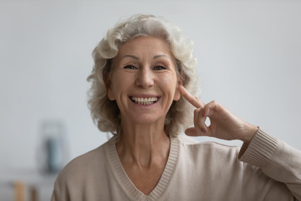 Elderly Woman Pointing at Her Ear