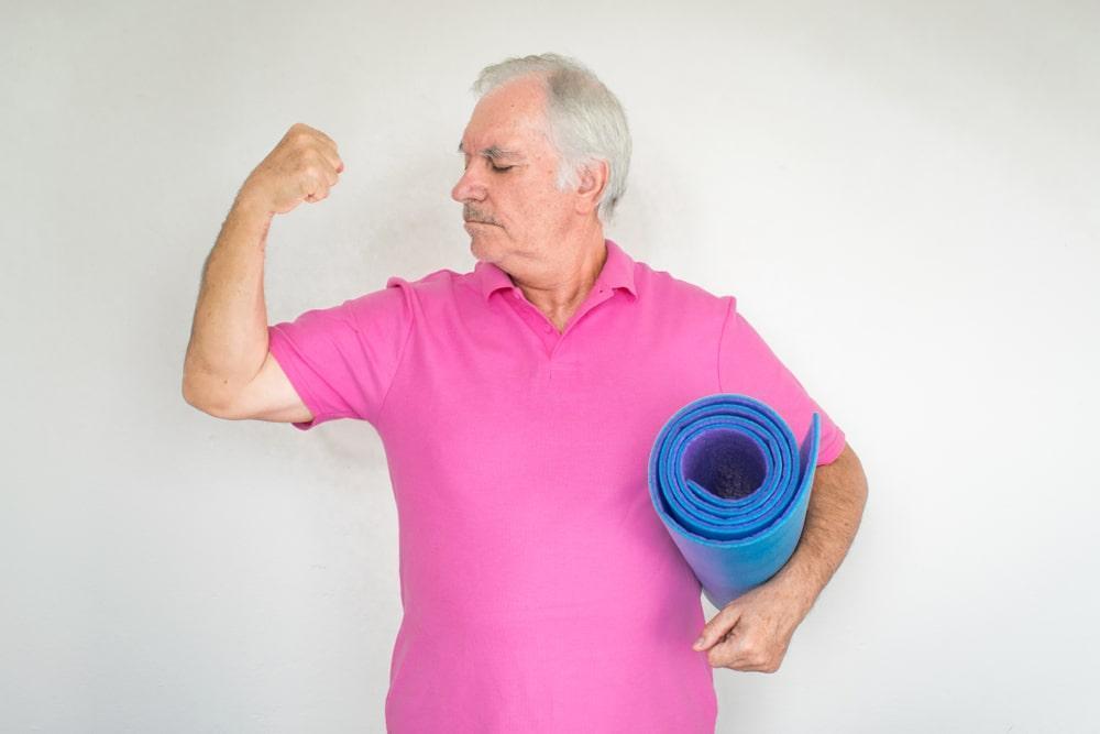 an elderly man looking at his muscles