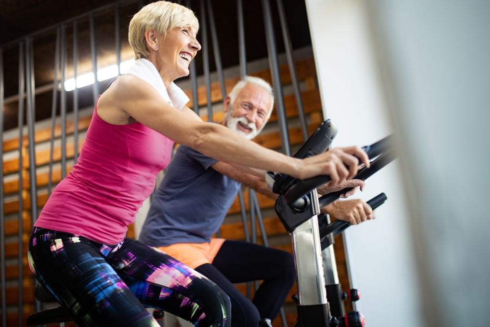 an elderly couple exercising and smiling