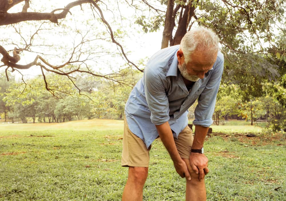 Aging Man Having Pain in His Knee in the Park