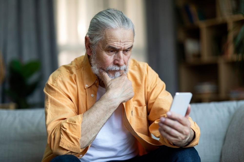 Concerned Man reading about joint pain on his phone