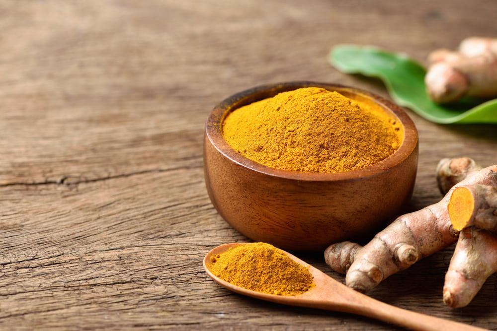 Ginger Powder in a Wooden Spoon and Bowl