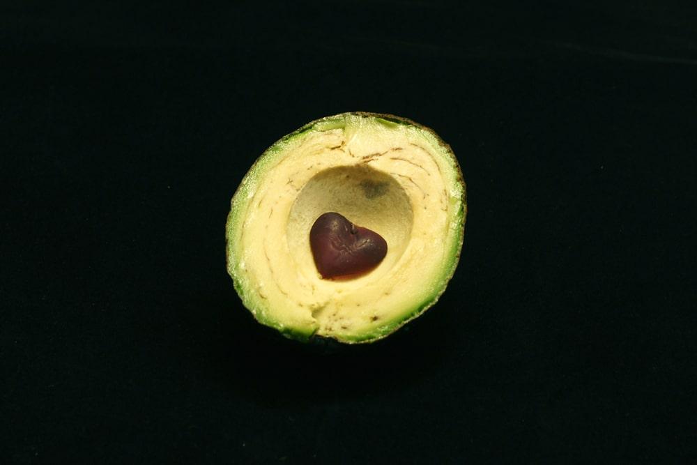 A Half of an Avocado With a Heart Shaped Seed