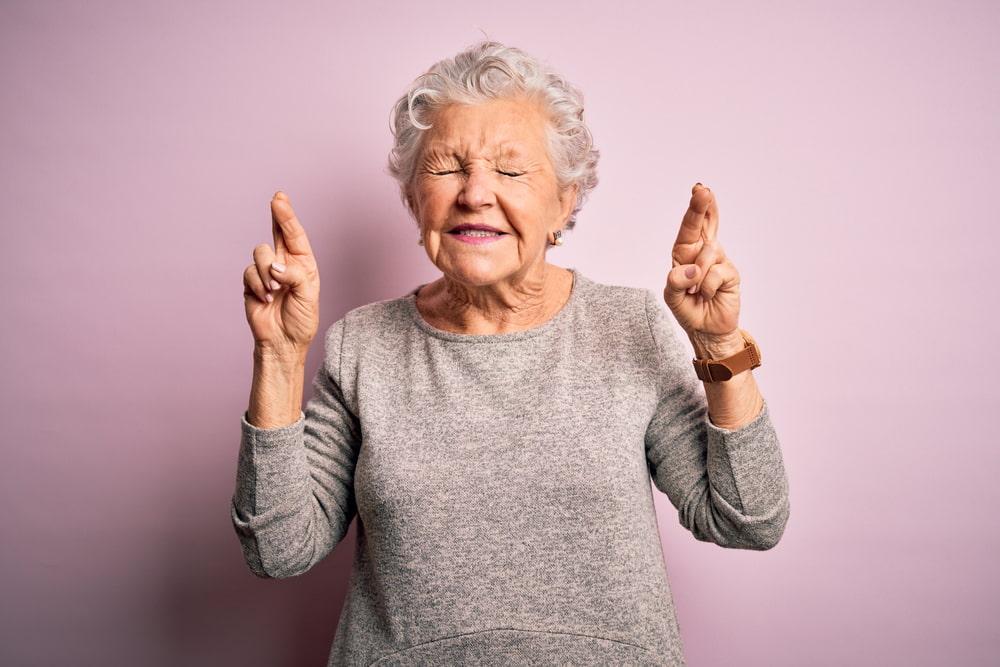 Old Woman Gesturing Finger Cross