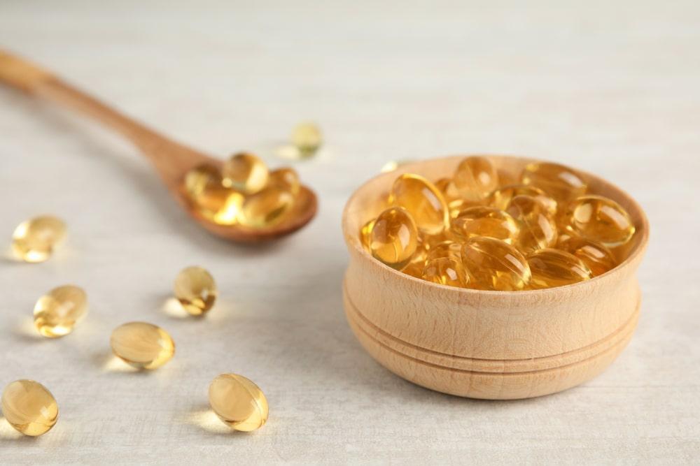 A Wooden Bowl With Omega-3 Fatty Acids in It Next to a Spoon