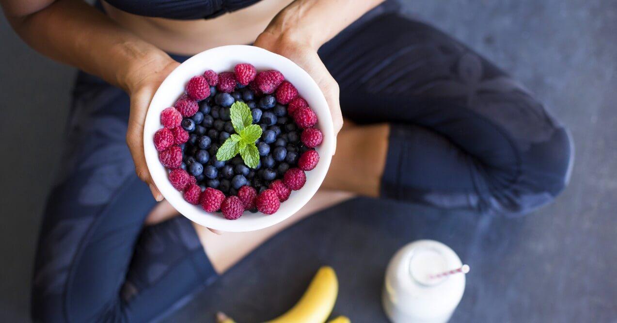 A close look of a woman holding a bowl with berries