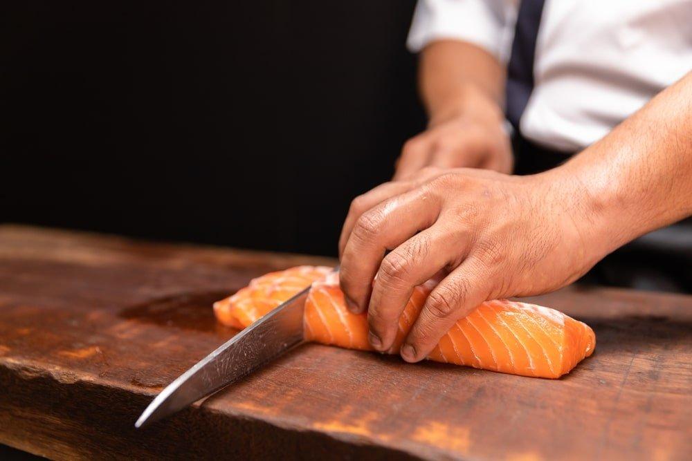 Chef’s Hand Holding Fresh Piece of Salmon