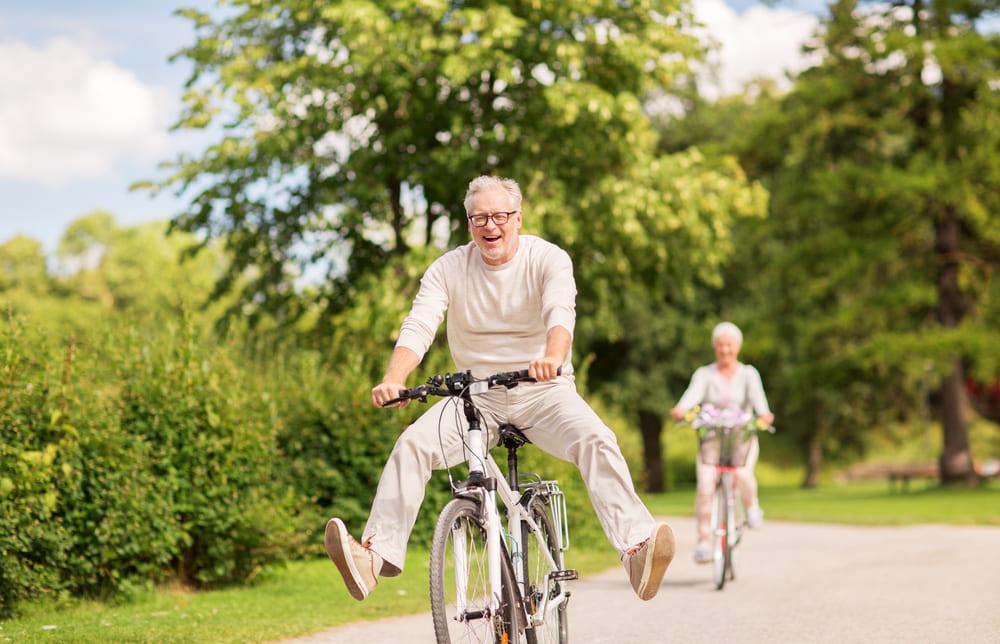 Happy Senior Couple Riding Bicycles at a Summer Park