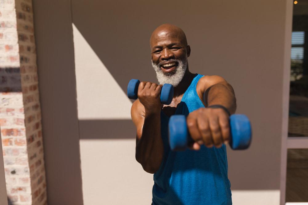 Senior African American Man Training Arms With Dumbbells