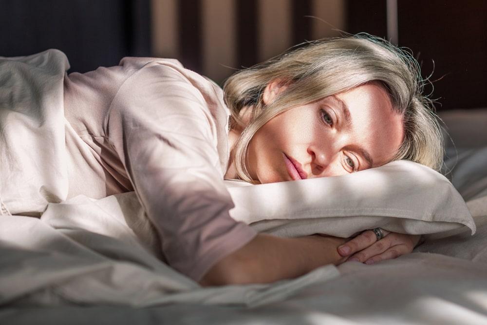 Woman Lying in Bed Caught in Her Thoughts