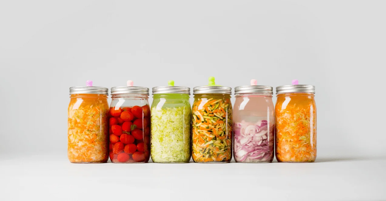 6 jars of probiotic vegetables in grey background