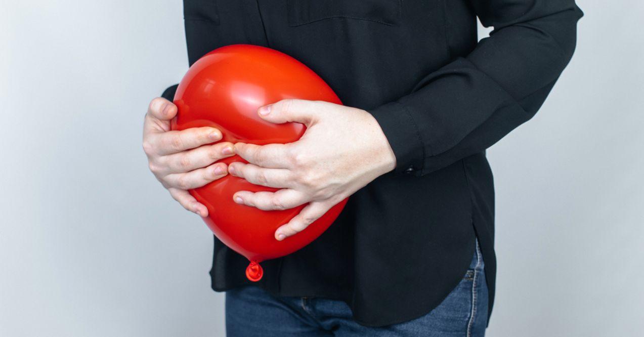 Woman Holds a Red Balloon Near the Abdomen, Which Symbolizes Bloating