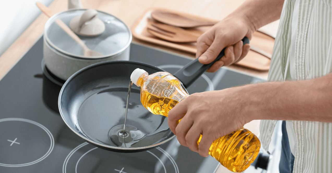 A Bottle of Vegetable Oil Poured in a Frying Pan