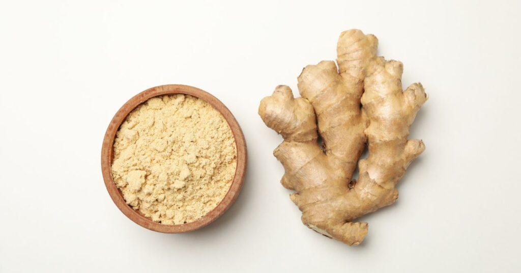 A Bowl of Grinded White Turmeric Next to a Whole White Turmeric