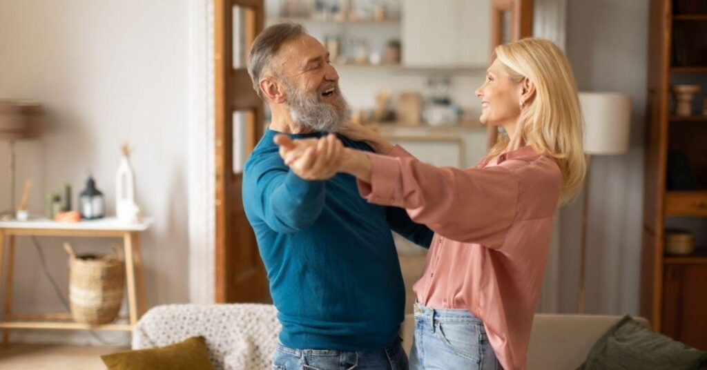 Senior Spouses Enjoying Time Together Dancing at Home