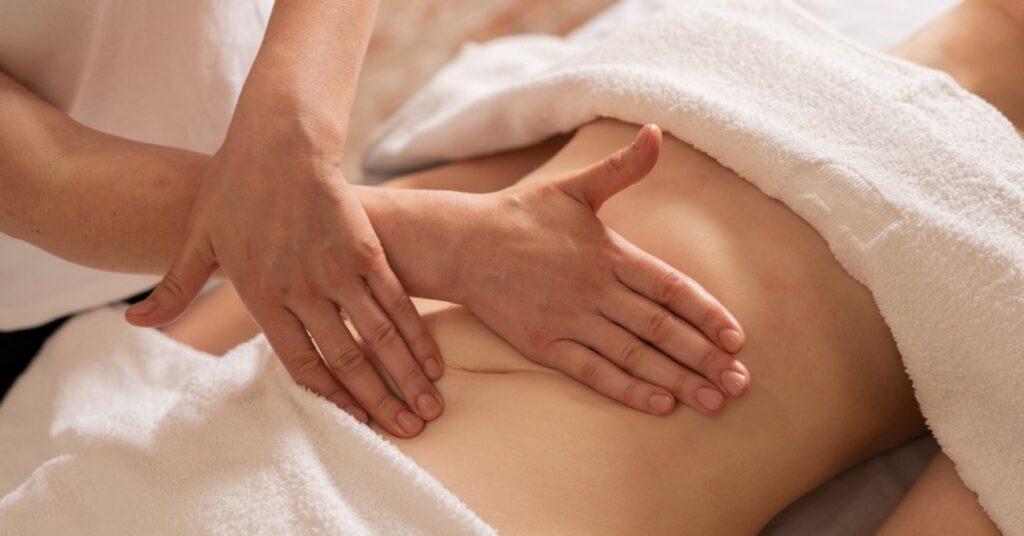 Hands Massaging Belly in the Spa Salon