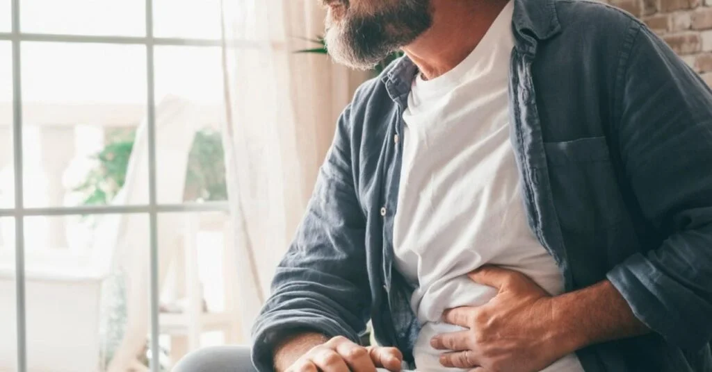 Hand of Mature Man Holding Abdomen Suffering From Ache, Diarrhea or Indigestive Problem