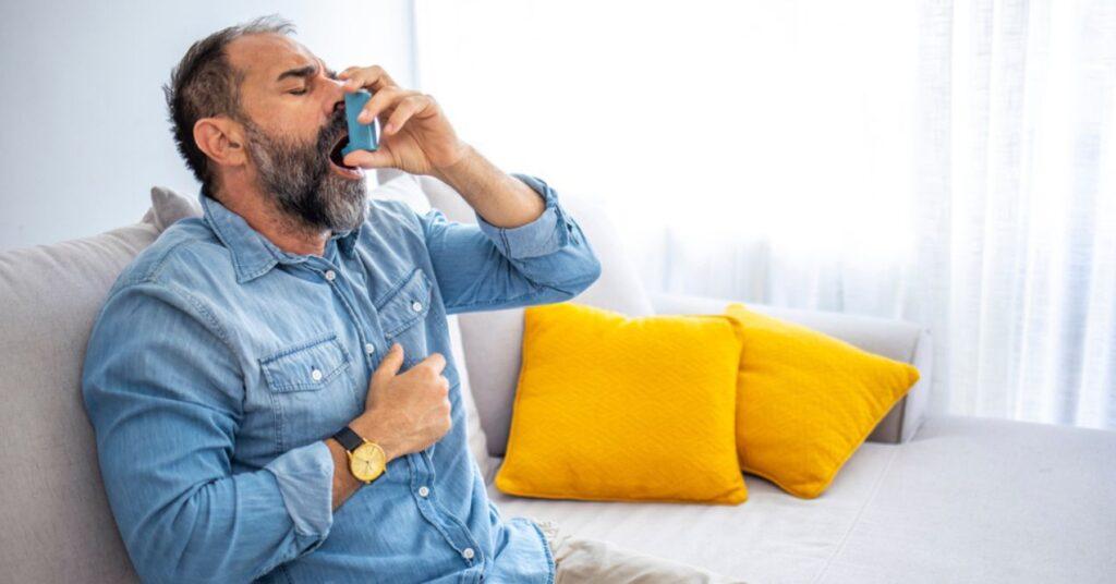 Man Using Medical Inhaler to Prevent and Treat Wheezing and Shortness of Breath