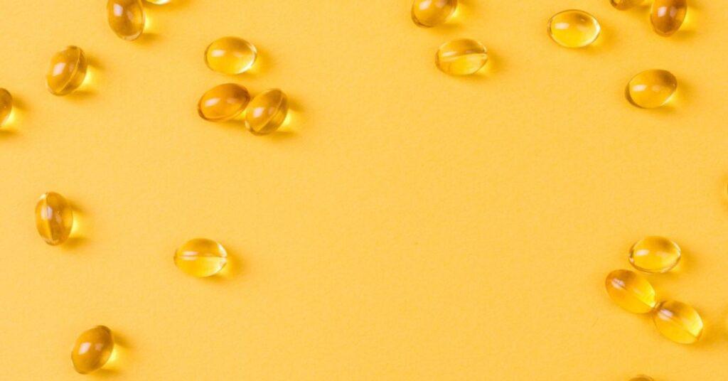 Close Up of Vitamin D Spread Around Yellow Background