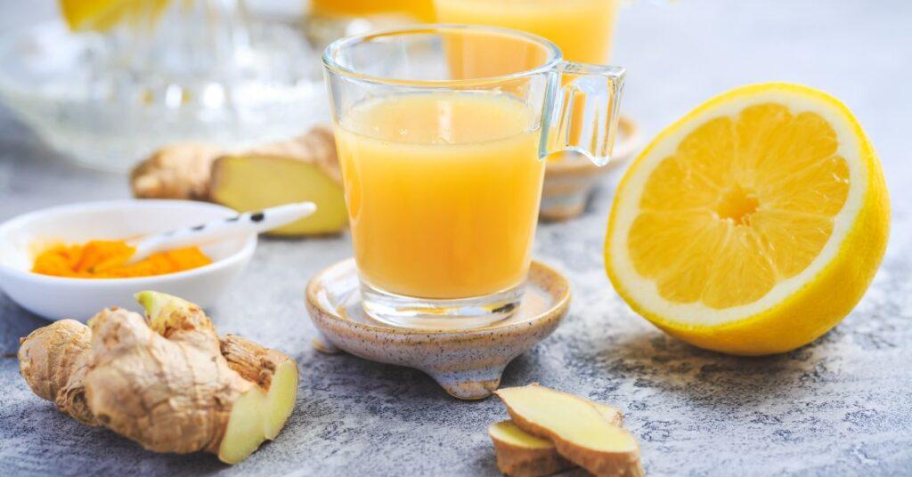 White Turmeric Scattered Around a Sliced Orange and Squeezed Orange Juice in a Glass