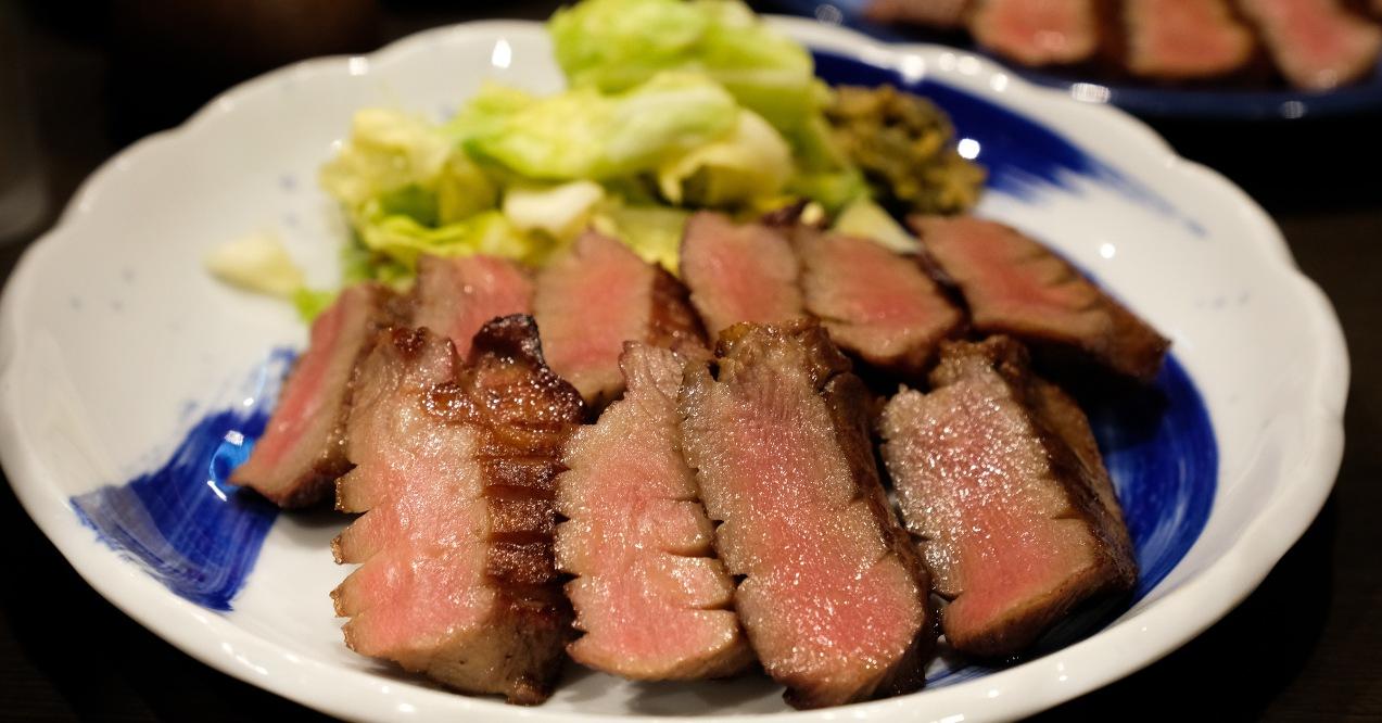 Zoomed slices of grilled beef and cabbage on a place