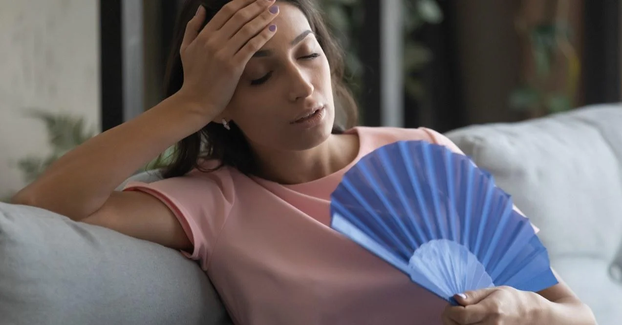 A woman feeling hot trying to cool down