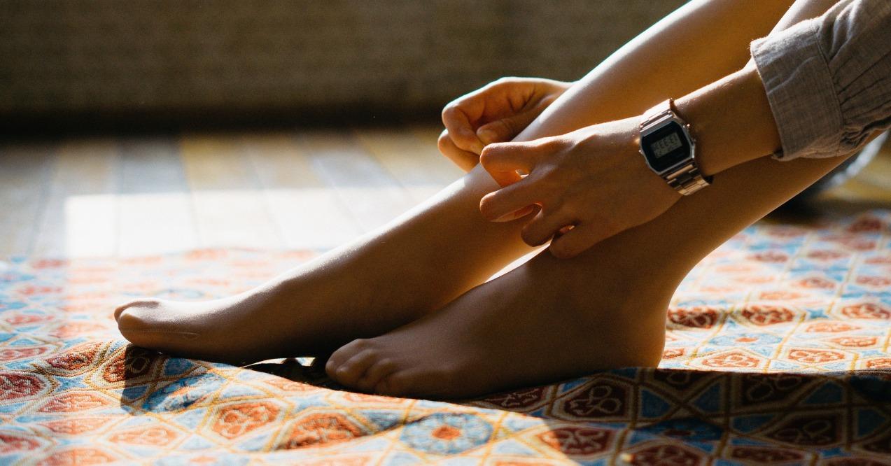 Woman wears beige stocking in the sunshine, zoomed in