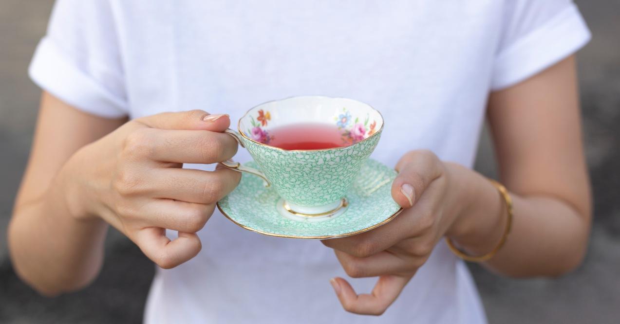 Female hands holding cup of tea for drinking