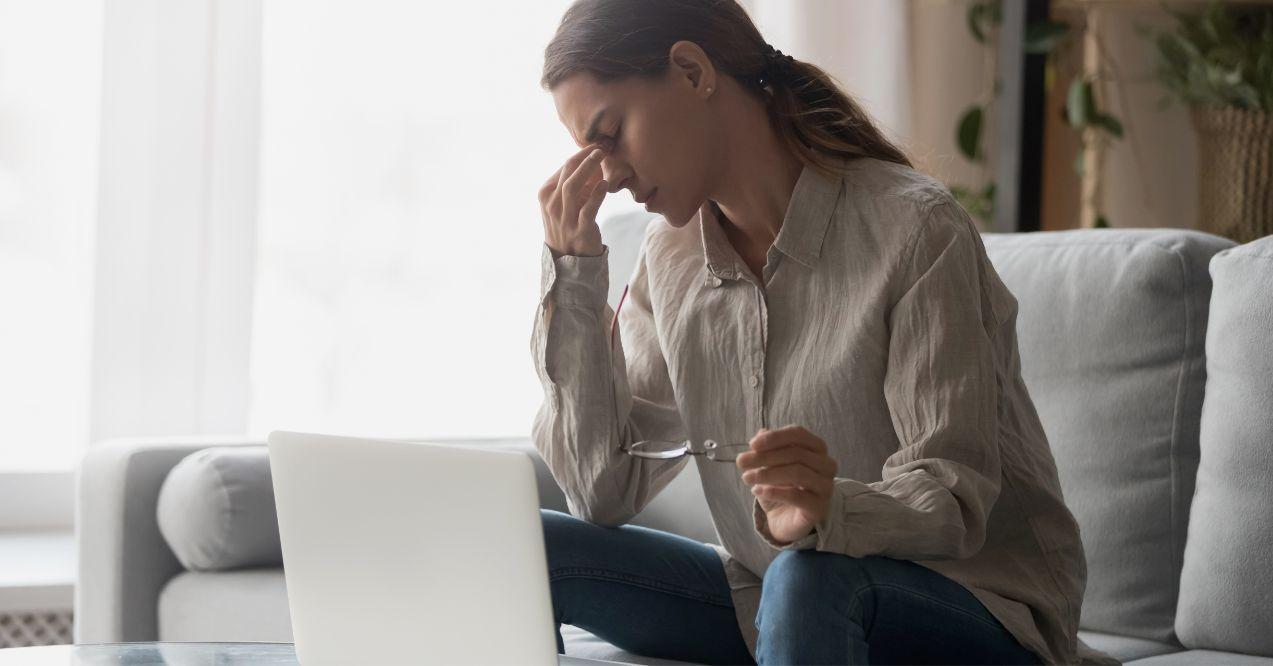 A woman feeling weak, tired or fatigue while sitting in front of a laptop.