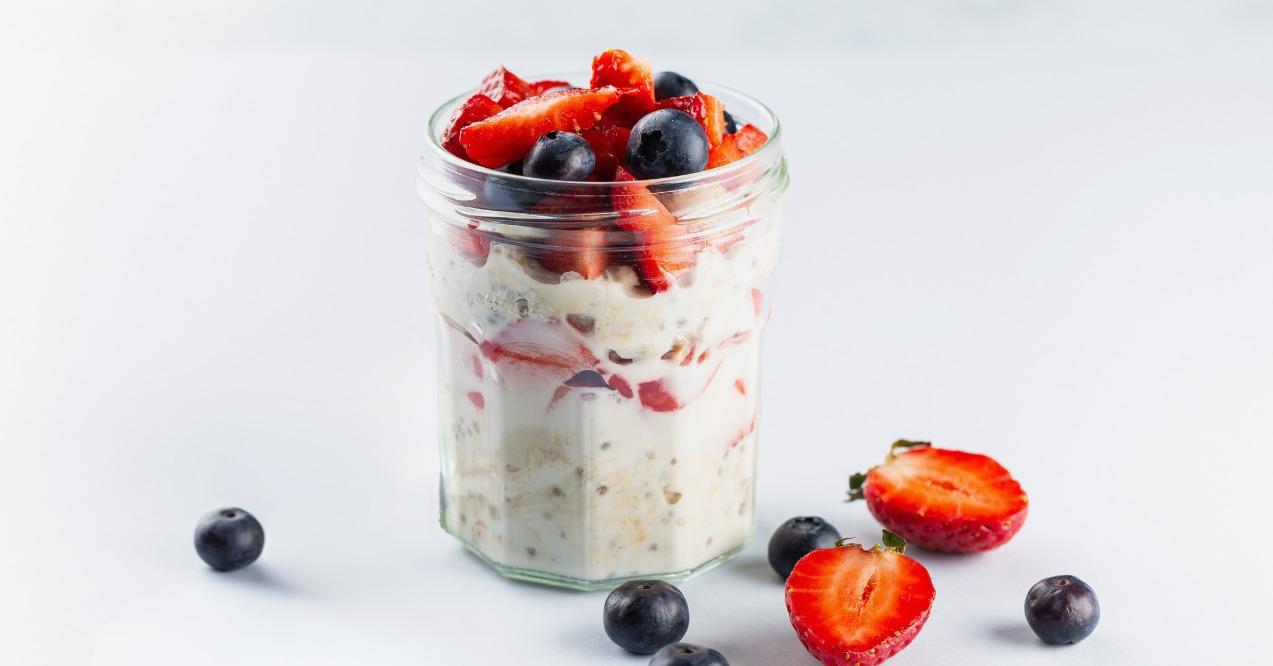 Overnight oats with chia seeds and fresh strawberries and blueberries in a glass jar