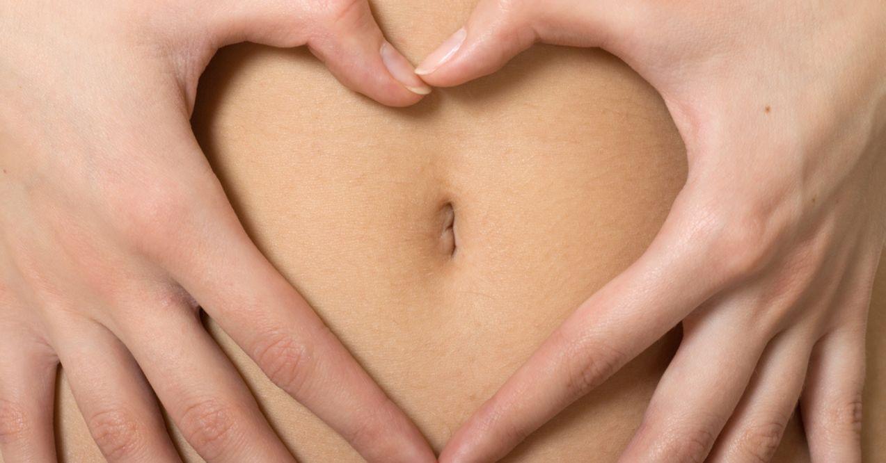 Woman Shaping a Heart Form With Her Hands Near Belly