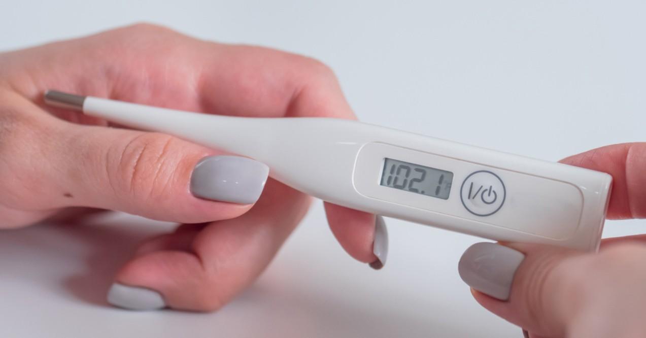 Woman Hands Holding White Digital Medical Thermometer With High Temperature