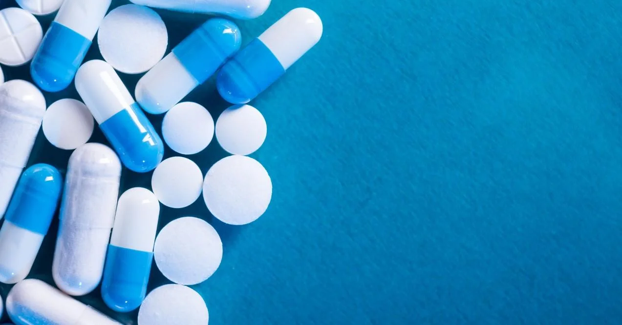 Antibiotic and Probiotic Pills on a Blue Background