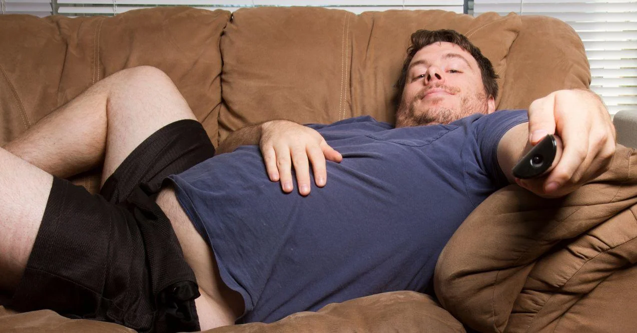 A Man Being Inactive by Laying in Bed and Watching TV