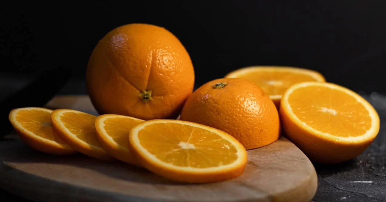 Sliced orange citrus fruit on a wooden board