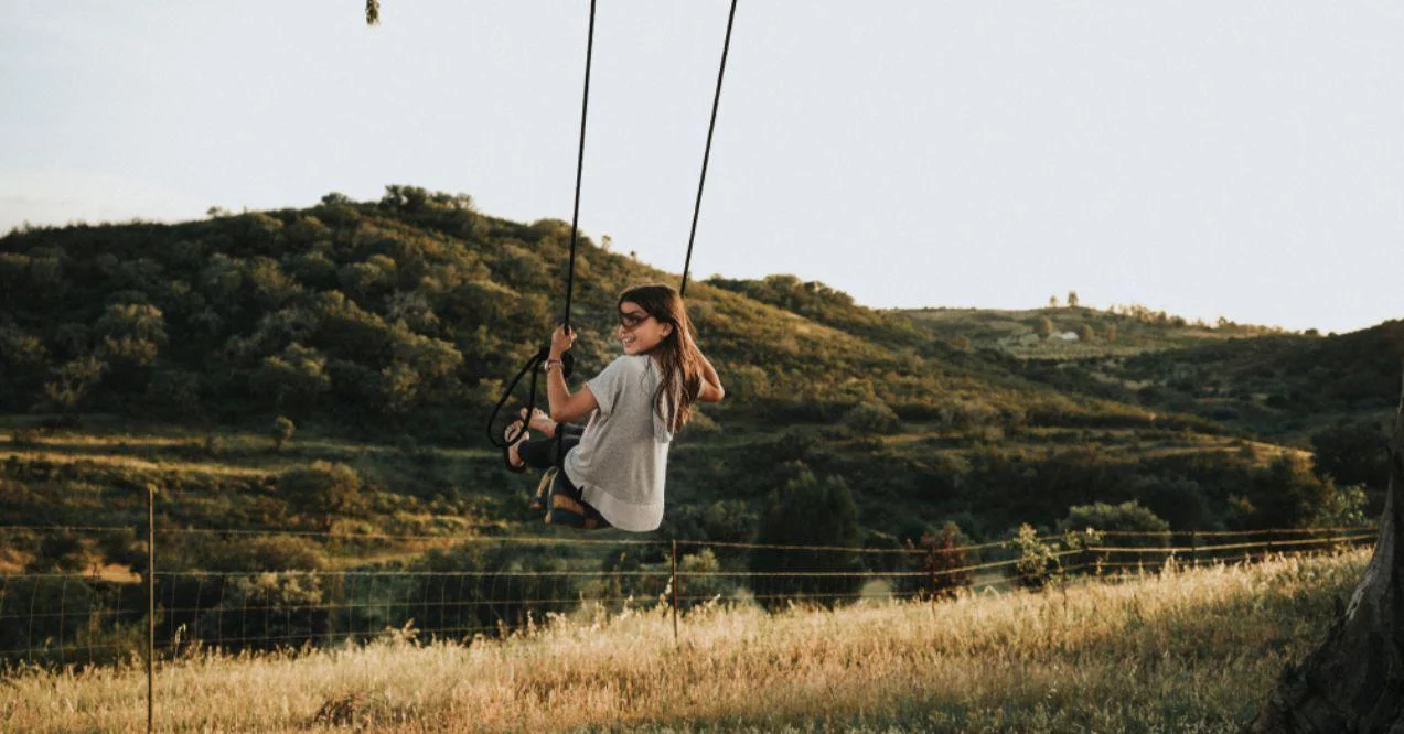 Father Swinging His Daughter on a Tire Attached to a Tree