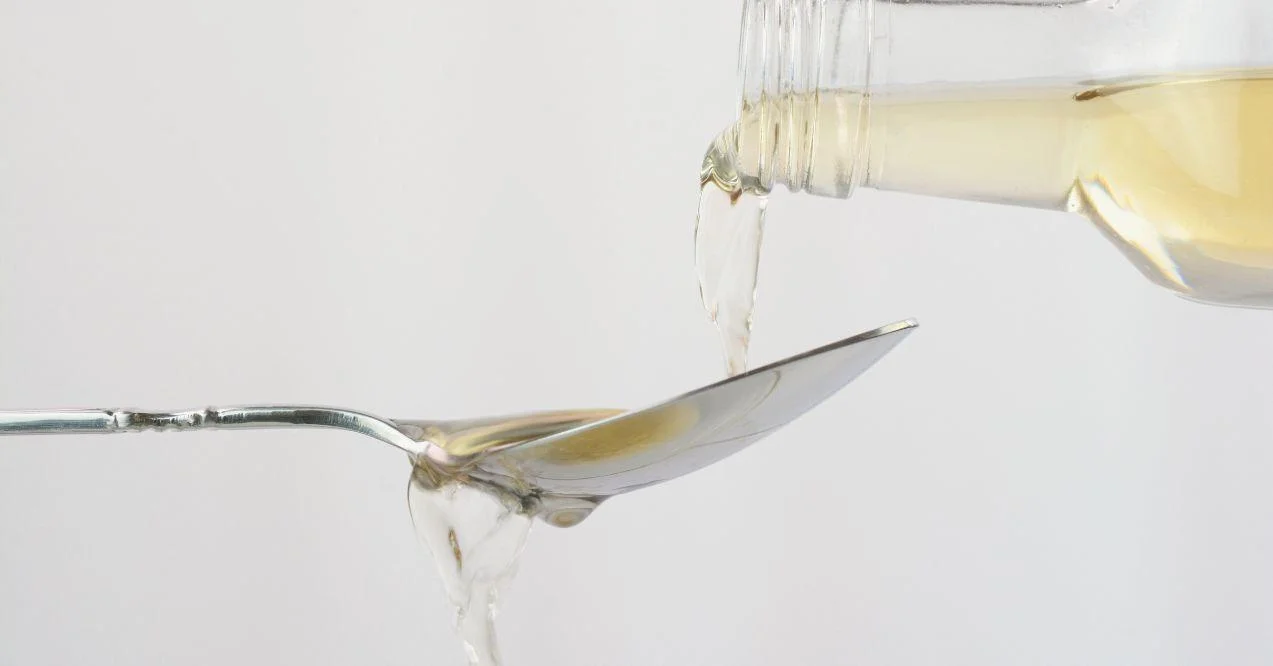 Pouring apple cider vinegar in a spoon. Zoomed in.