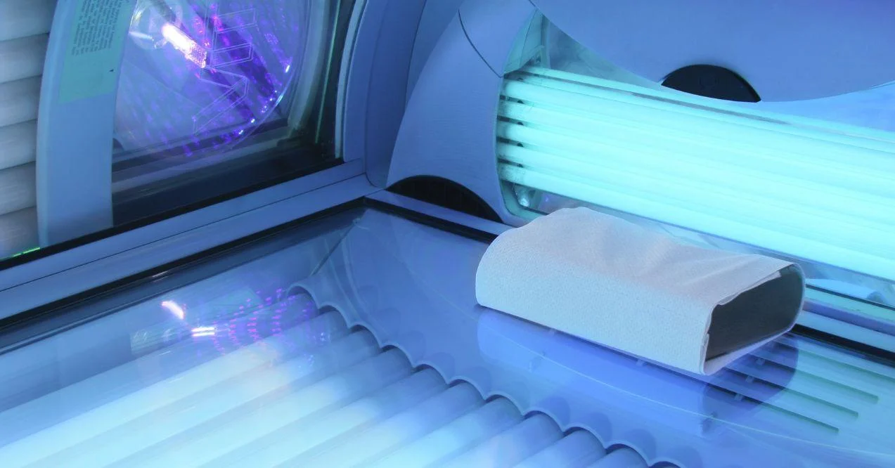 Solarium empty tanning bed view from inside with closed lid and all light bulbs glowing on.