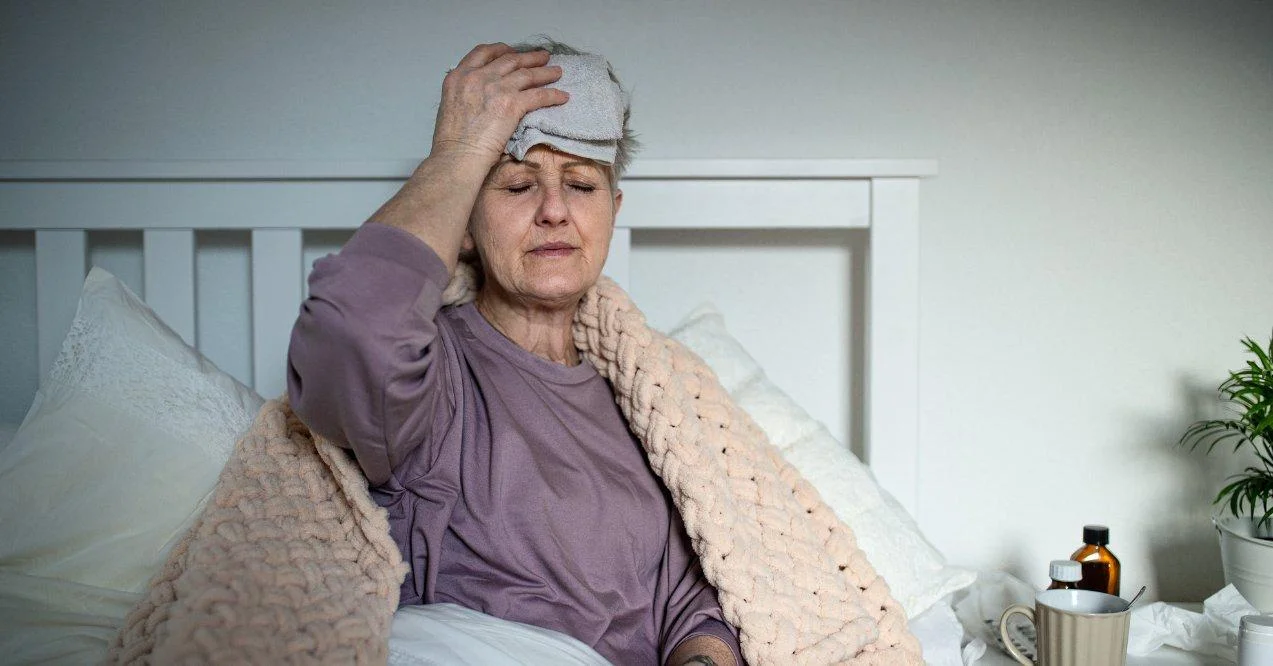 elderly woman with a headache sitting on bed