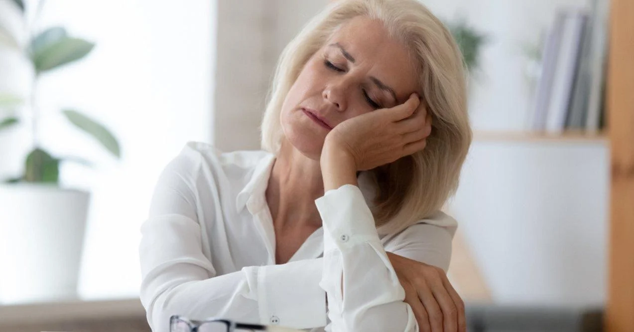 Exhausted Aged Woman Worker Sitting at Office Desk