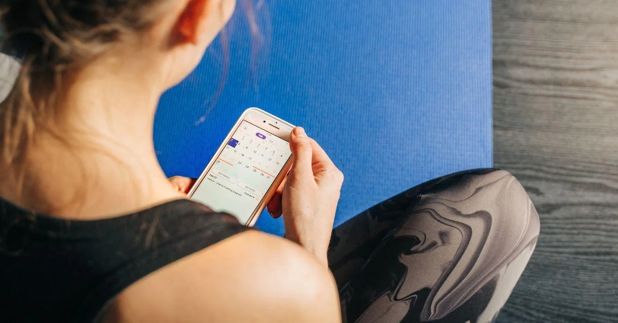 Young fitness woman phone online application track menstrual cycle.